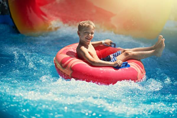 kid at waterpark in floaty raft in the water