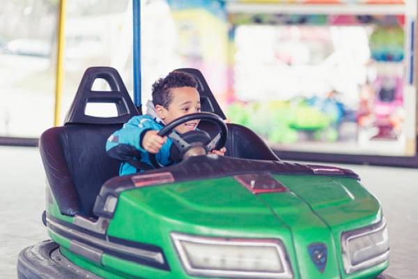 little boy in a green bumper car