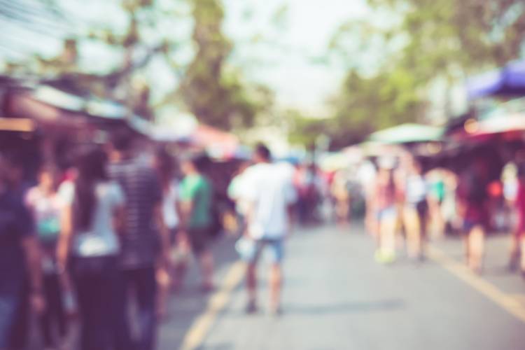 view of a street festival that is blurry with people walking by