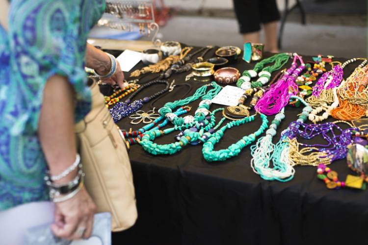 woman at festival booth with brightly colored necklaces and jewelry woman at festival booth with brightly colored necklaces and jewelry